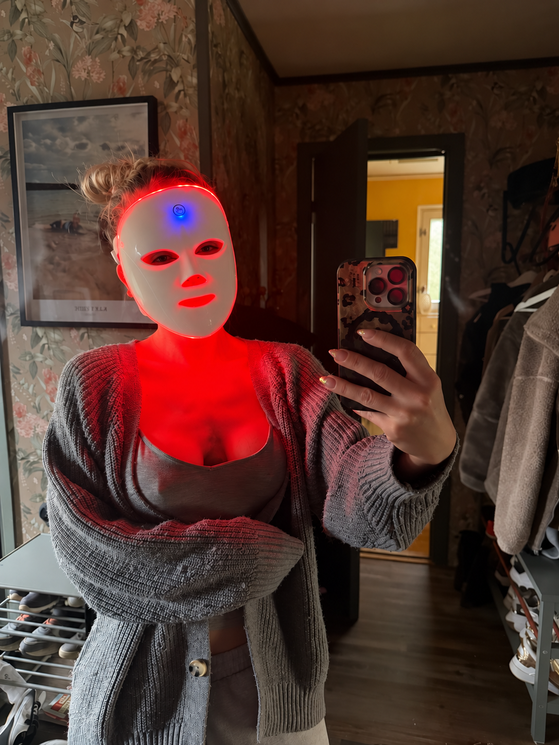 Kvinna speglar sig med LED-masken i rött ljus