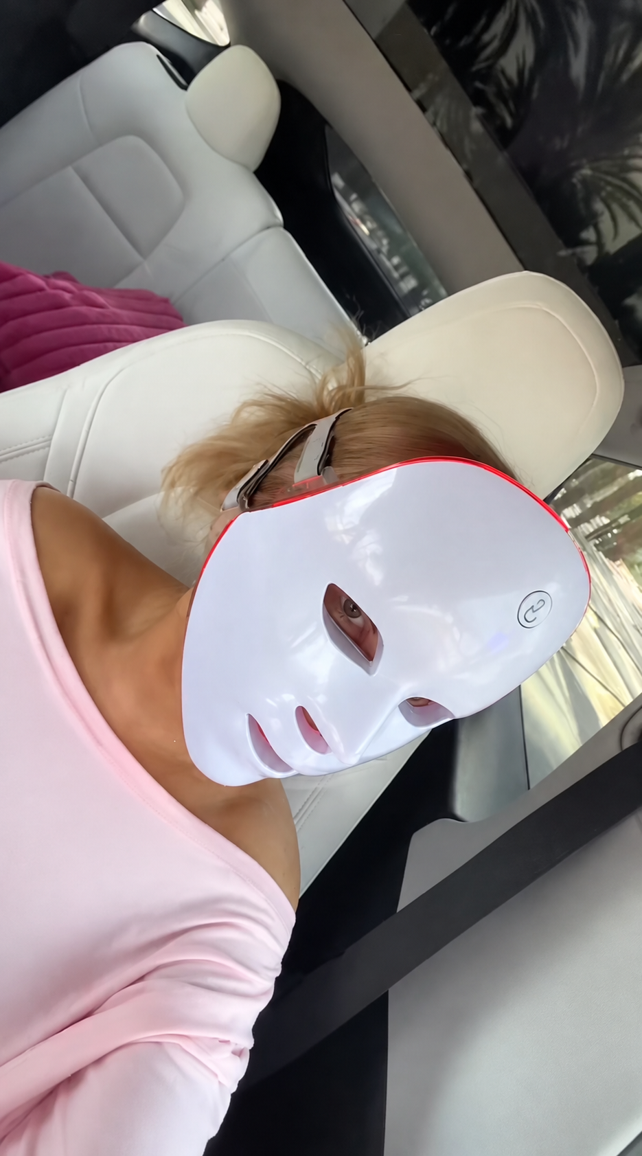Kvinna sitter i en parkerad bil med LED-masken